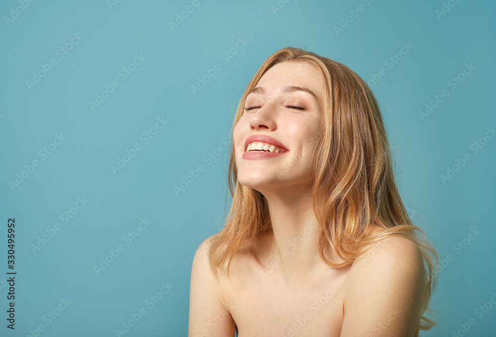Portrait of beautiful young woman laughing on blue background Portrait of beautiful young woman laughing on blue background