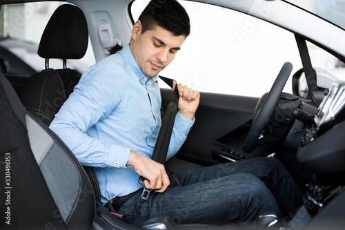 Guy Putting On Seat Belt Sitting In Car © Prostock-studio