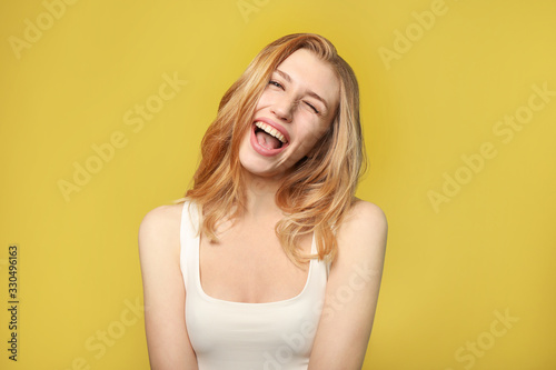 Portrait of beautiful young woman laughing on yellow background © LumenSt