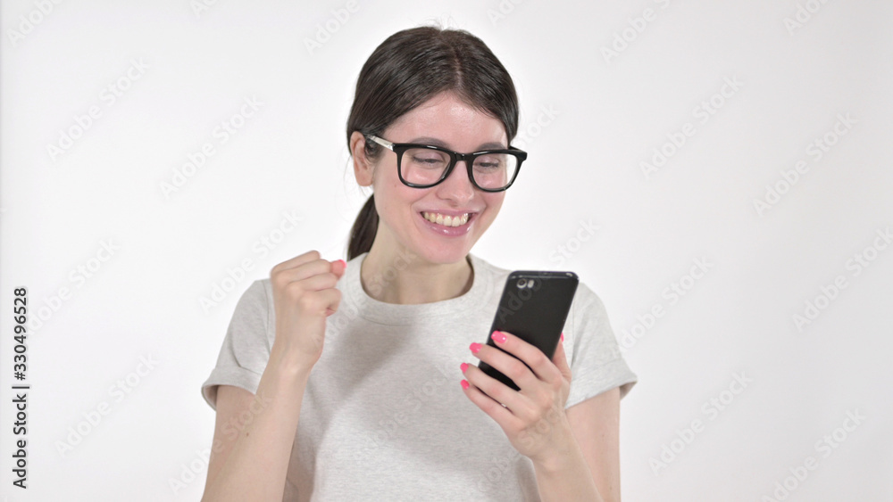 The Excited Young Woman Looking at Phone and Celebrating on White Background