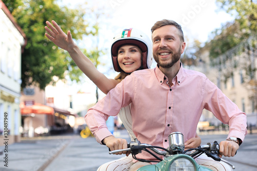 Young couple in love riding a motorbike. Riders enjoying themselves on trip. Adventure and vacations concept.