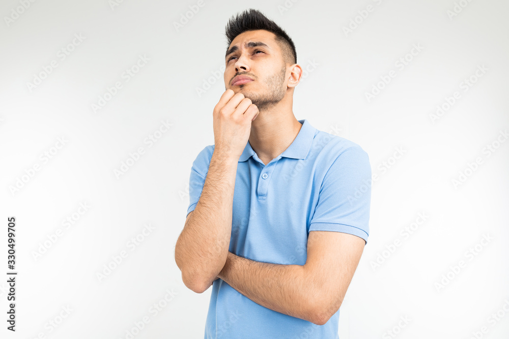 man with a blue t-shirt thoughtful on a white studio background man with a blue t-shirt thoughtful on a white studio background