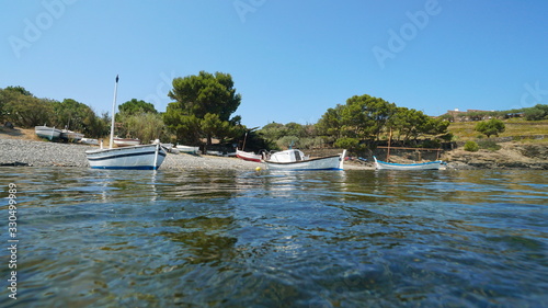 Mediterranean sea typical boats moored near beach shore, Spain, Port Lligat, Cadaques, Costa Brava, Catalonia