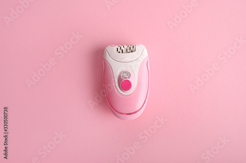 Pink epilator on a pink background. Hair removal concept.