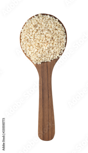 The seeds of the white sesame seeds on a wooden spoon and isolated on white background with clipping path