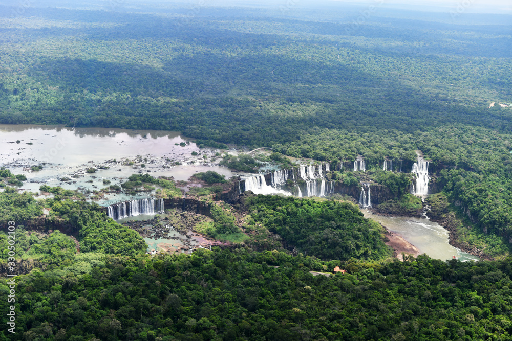 roaring waterfalls in the wild jungle from a helicopter