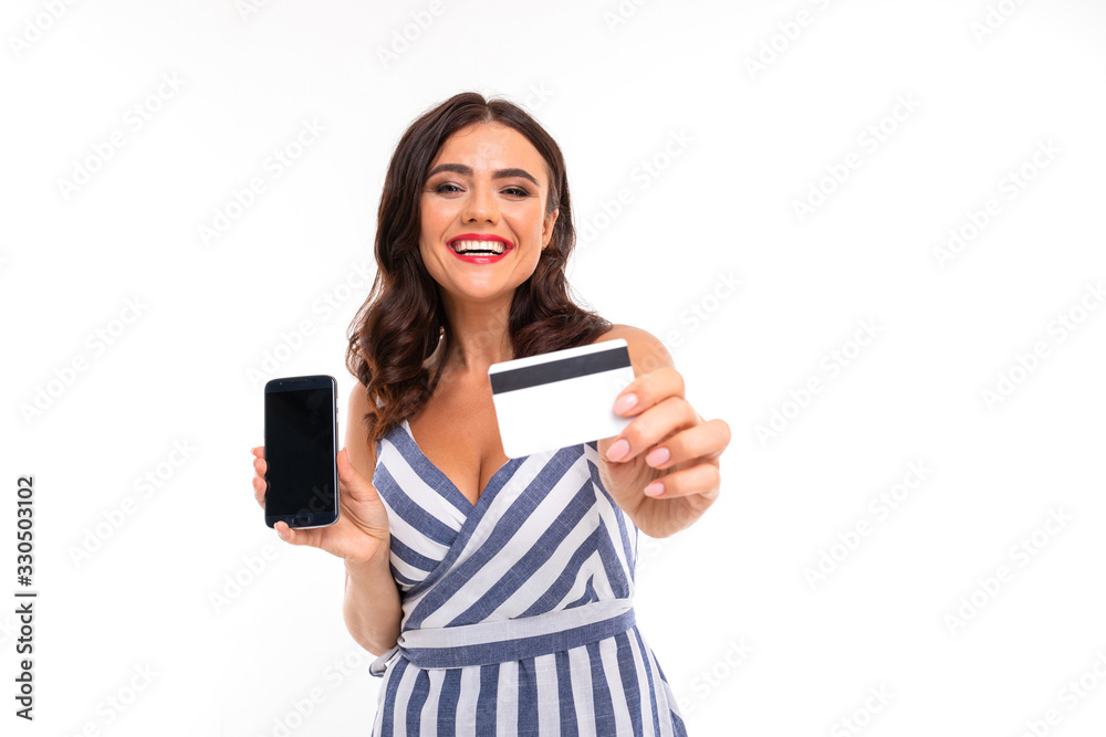 Portrait of nice caucasian girl holds a phone and credit card isolated on white background