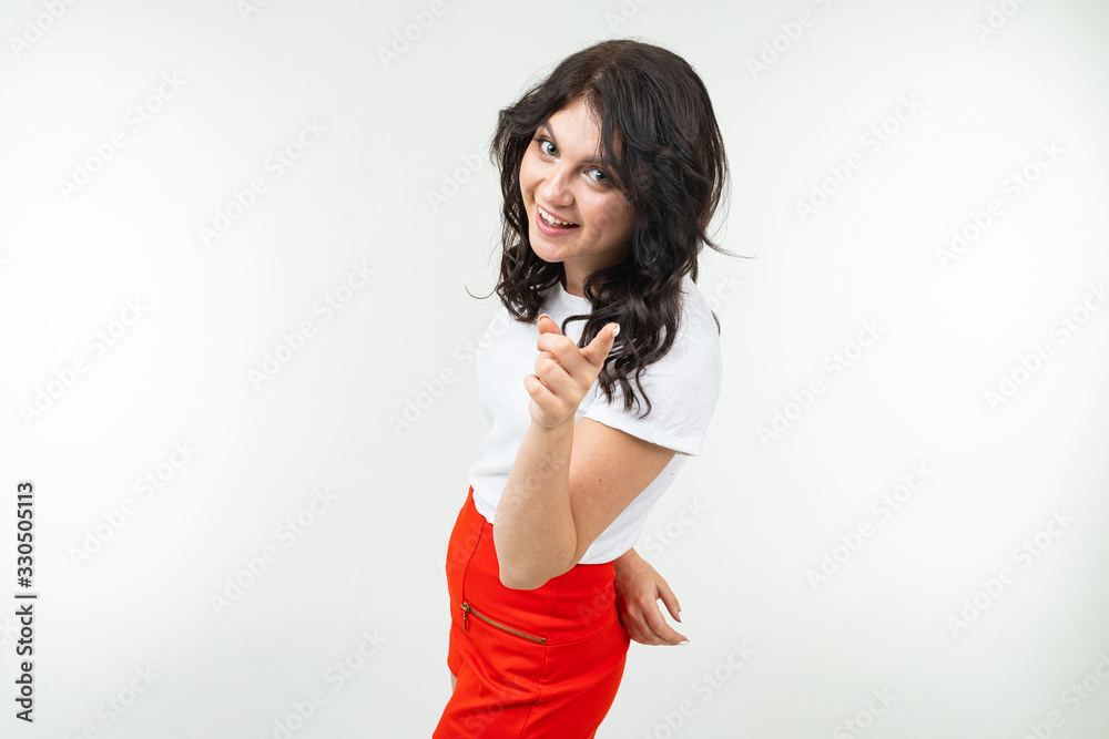 energetic bright brunette in a white tank top and red pants on a white background energetic bright brunette in a white tank top and red pants on a white background