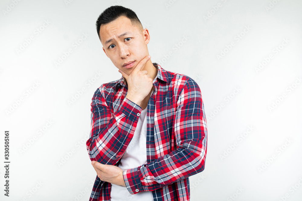 handsome asian man in a checkered shirt wide open isolated on a white studio background with copy space handsome asian man in a checkered shirt wide open isolated on a white studio background with copy space