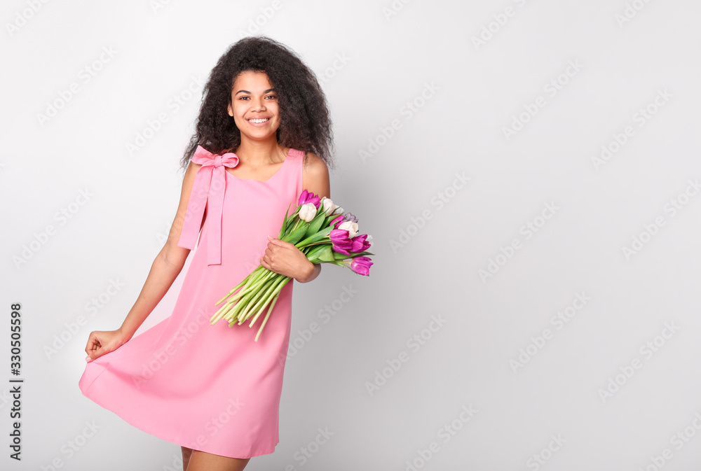Young african woman with flowers on white background. Women's day concept Young african woman with flowers on white background. Women's day concept