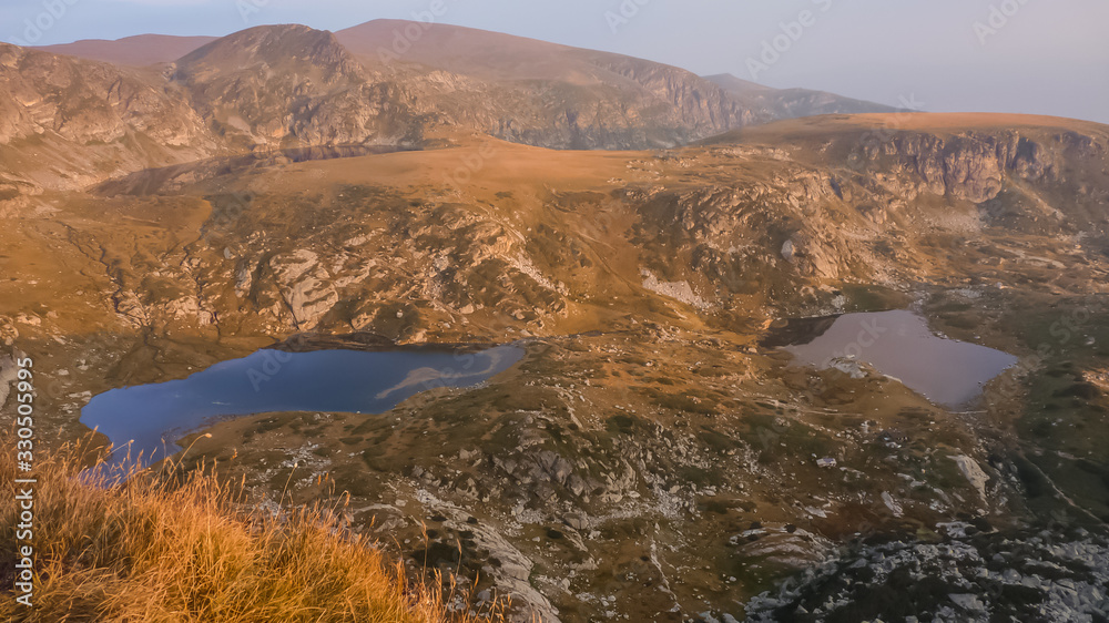 The Seven Rila lakes area, Rila national park,Bulgaria - October CIRCA,2019. Sunset view from the top of Haramiyata mount in late autumn. Seven Rila lakes from above in warm  light.