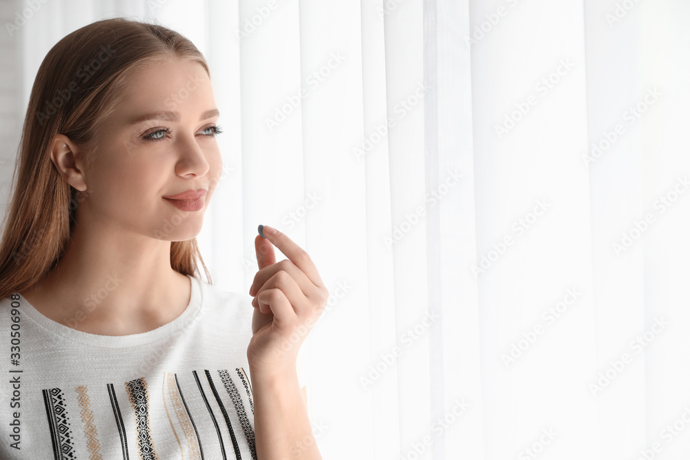 Young woman with vitamin pill indoors. Space for text Young woman with vitamin pill indoors. Space for text