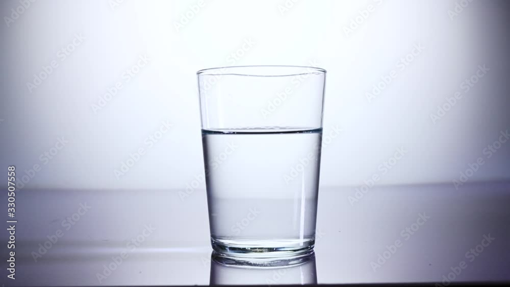 ice cube falling in glass of water ice cube falling in glass of water