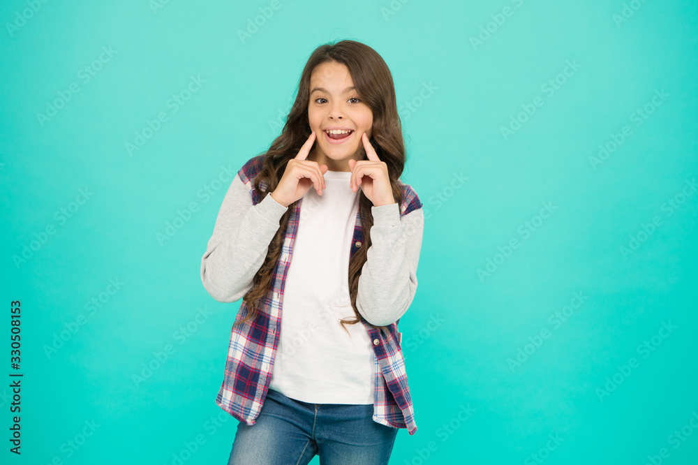 healthy toothy smile. smiling schoolgirl has long curly hair. child wear casual jacket. kid spring and autumn fashion. little beauty. express positive emotions. happy small girl turquoise background healthy toothy smile. smiling schoolgirl has long curly hair. child wear casual jacket. kid spring and autumn fashion. little beauty. express positive emotions. happy small girl turquoise background