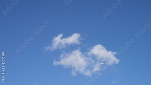 푸른 하늘 아래 구름 밑을 지나가는 여객기
