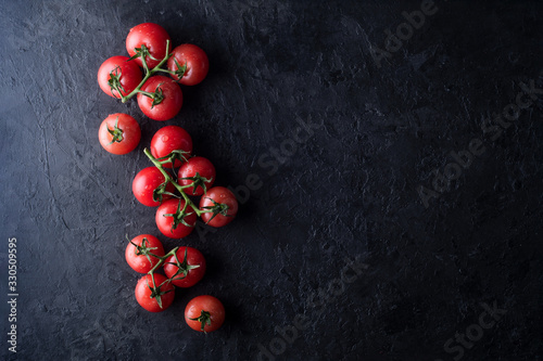Red tomatoes on a dark concrete background. Top view. Fresh juicy tomatoes.