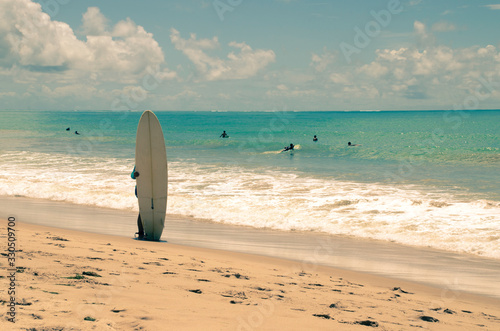 Surfer standing on the beach