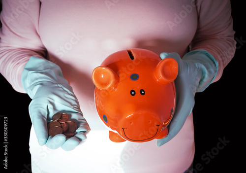 concept image topic coronavirus crisis, piggy bank, hands in gloves and euro coins photo