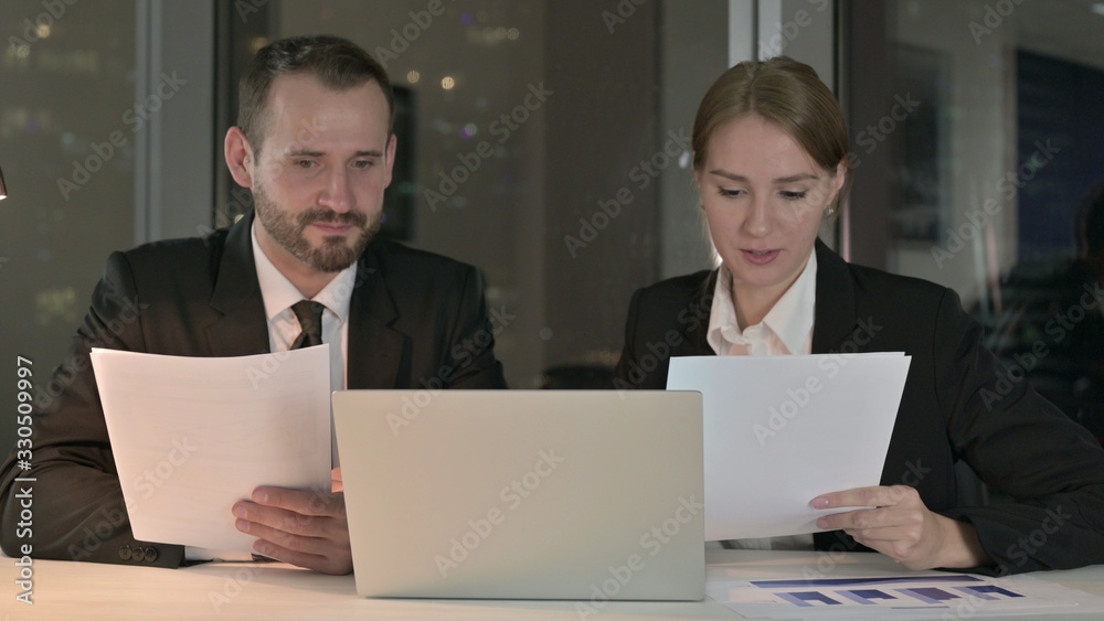 The Business people Reading Documents at Night The Business people Reading Documents at Night