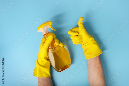 Hands holding cleaning product on blue background