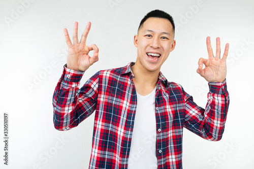 Asian man in a checkered shirt wide open shows super on an isolated white studio background photo