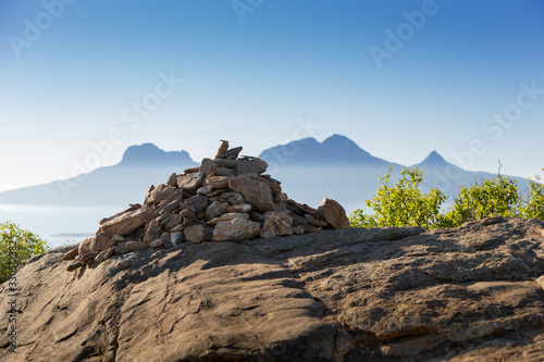 Fotografie A cairn in the foreground of the island Landegode outside Bodø city