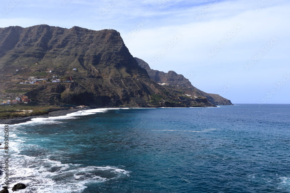 Fototapeta premium view to the village Hermigua on the Canary island La Gomera with multi colored houses and palm trees