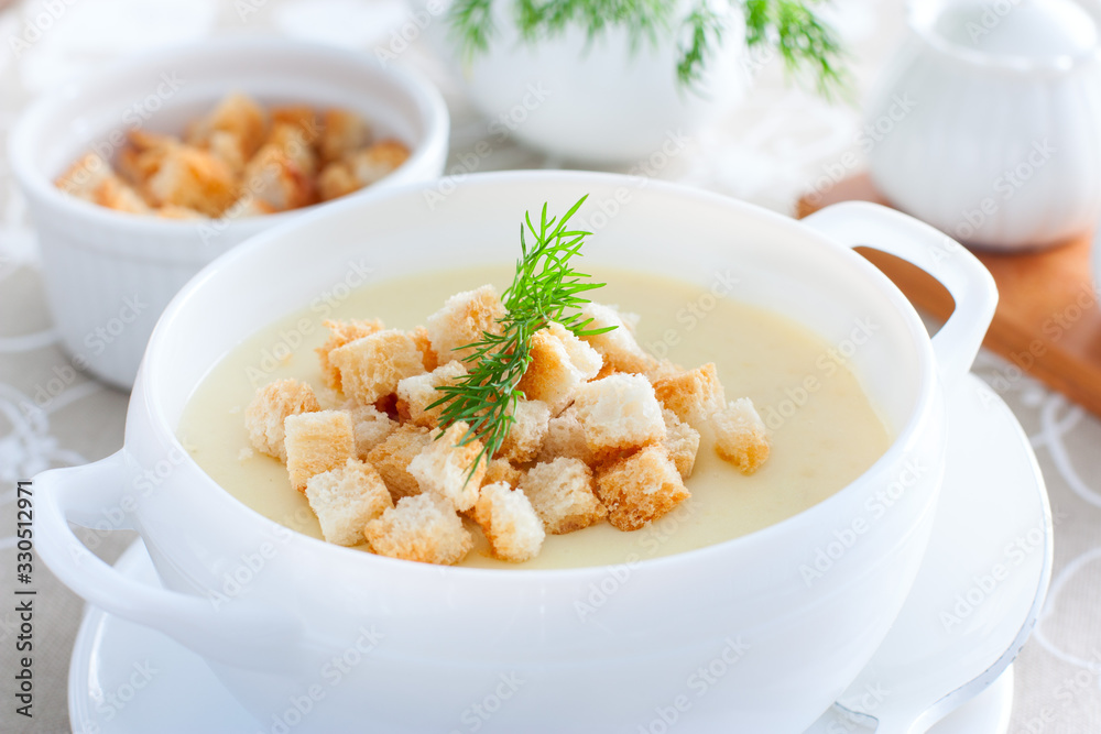 Mashed potato soup with homemade croutons in a white soup plate, horizontal Mashed potato soup with homemade croutons in a white soup plate, horizontal
