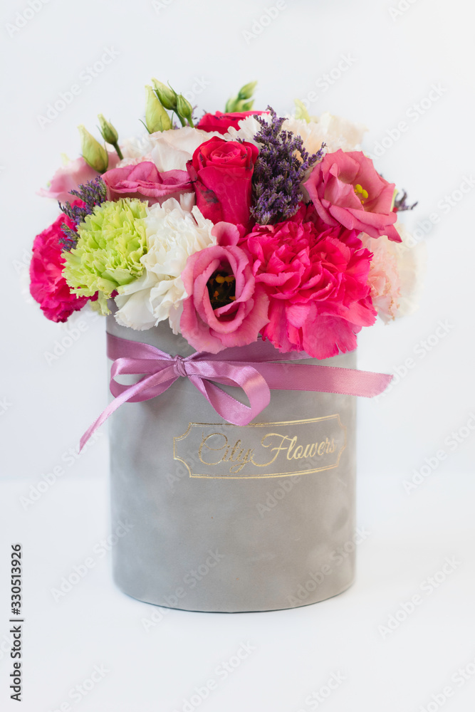 Beautiful tender bouquet of flowers in grey box on white background Beautiful tender bouquet of flowers in grey box on white background