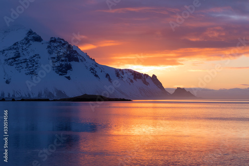 Incredible winter sunrise on the coast of Iceland, with the Stokksness Mountains in the background and a colorful sky