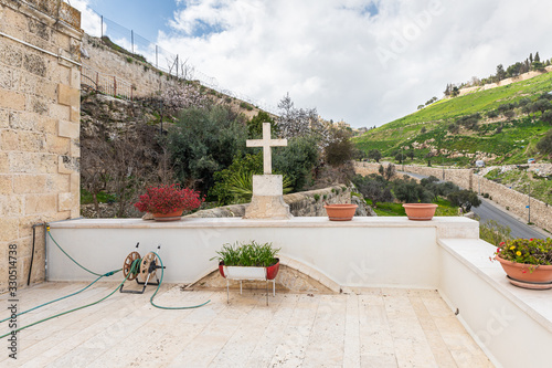 A large stone cross stands on the balcony of the Greek Akeldama Monastery in the old city of Jerusalem in Israel photo