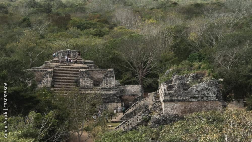 Telephoto time lapse of people climbing Ek Balam Mayan ruins and their jungle setting in Yucatan, Mexico. Telephoto time lapse of people climbing Ek Balam Mayan ruins and their jungle setting in Yucatan, Mexico.