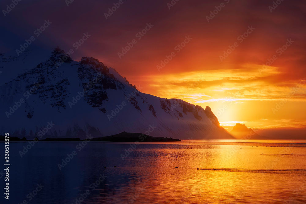 Incredible winter sunrise on the coast of Iceland, with the Stokksness Mountains in the background and a colorful sky