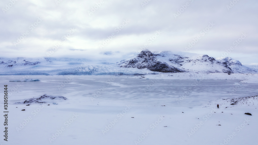 Panoramic view of a glacial lagoon in winter with the mountains in the background