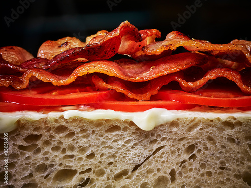 An open bacon and tomato sandwich with butter on white bread photo