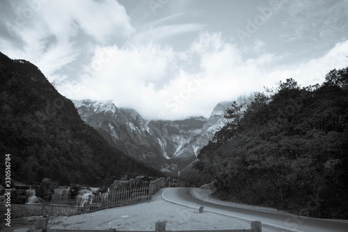 snow mountain view with mountain range and road lane in black and white color