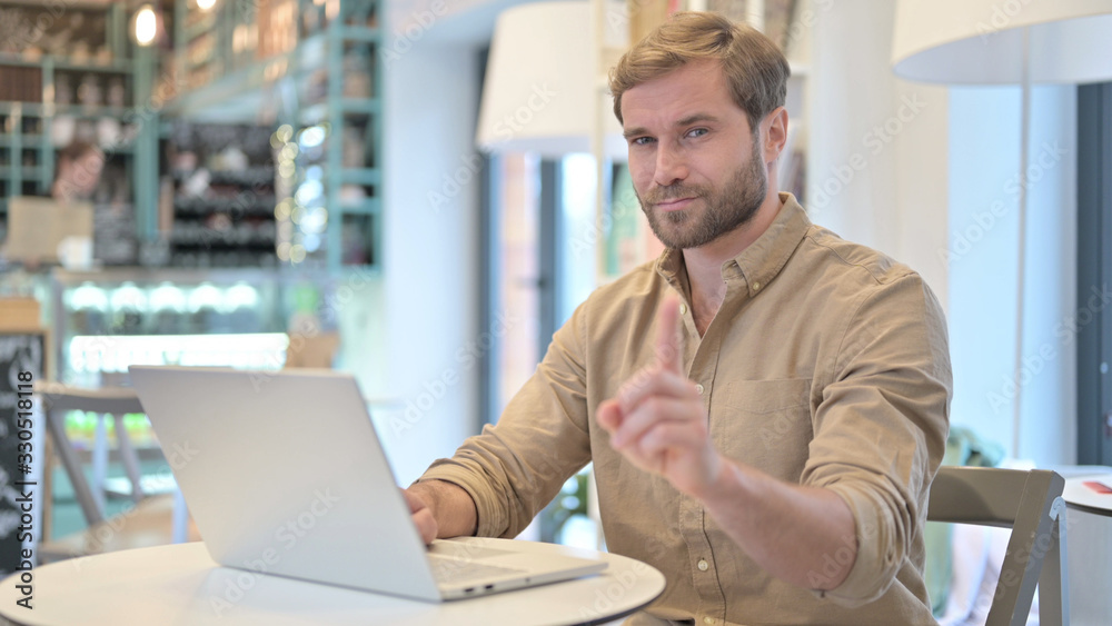No, Finger Gesture by Young Man with Laptop in Cafe No, Finger Gesture by Young Man with Laptop in Cafe