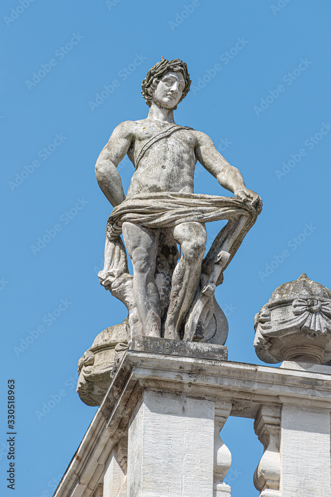 Old roof statue of a Renaissance Era naked Roman philosopher and poet in Leipzig downtown, Germany, details, closeup