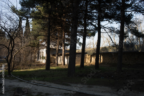 Abandoned burned old house in winter at sunset in forest. Abandoned hunting lodge in the warm rays of the sun in the middle of the forest.