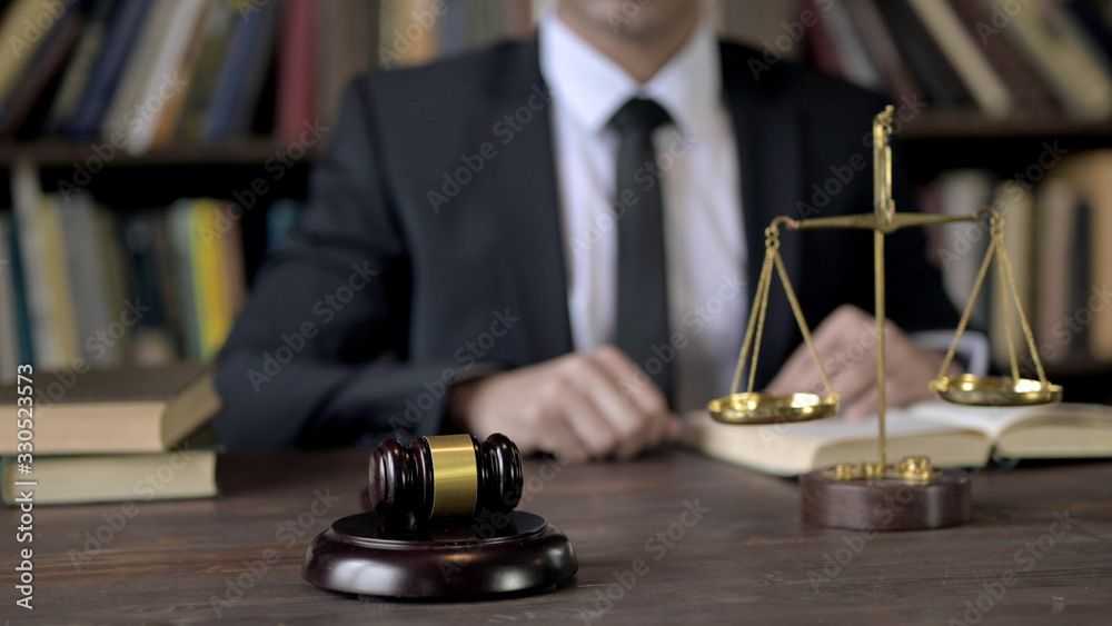Gavel and Gold Brass Balance Scale with Judge in Background