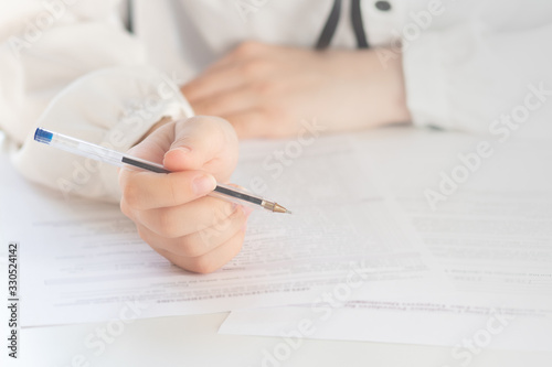 Drawing up a tax return. Hands holding a pen for signature