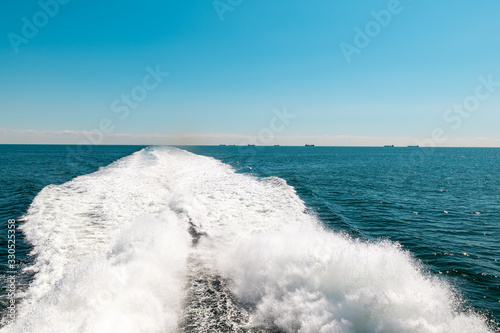 Sailing fast boat at sea, trail behind boat on water © Jan Rozehnal
