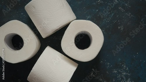 Slow motion man takes last toilet paper roll from a dark blue store shelf. Top view, close-up