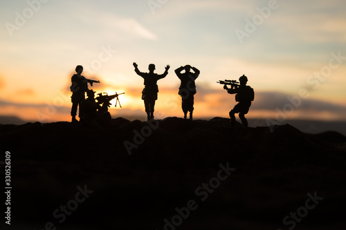 Battle scene. Military silhouettes fighting scene on war fog sky background. A German soldiers raised arms to surrender.