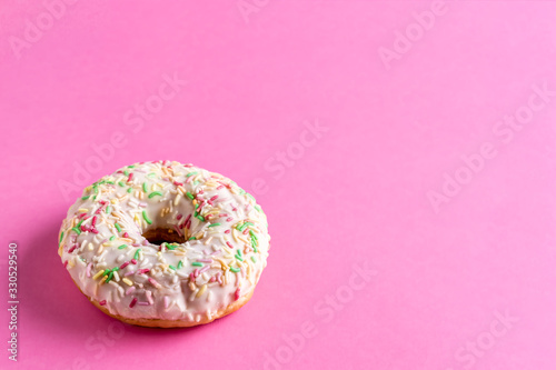 Pink frosting donut on pink background