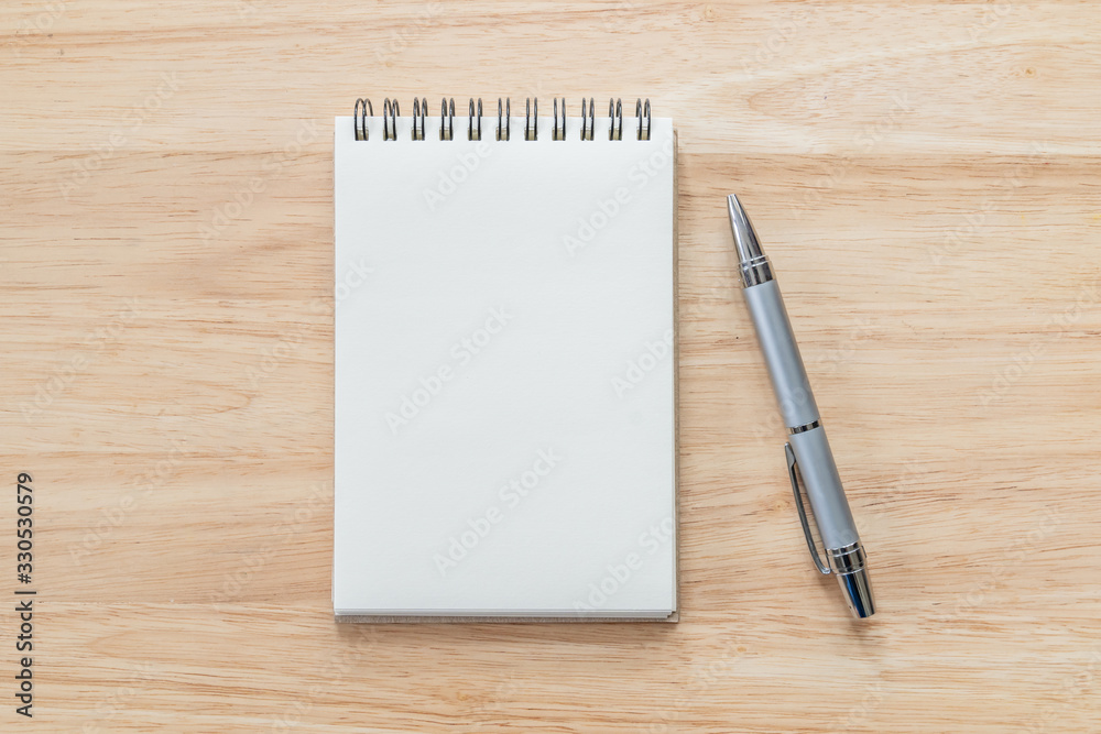 Top view of blank notebook with pen and natural light on wooden table. Top view of blank notebook with pen and natural light on wooden table.