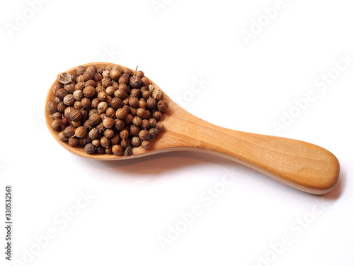 Dried spices and herbs with coriander seed in wooden spoon isolated on white background.