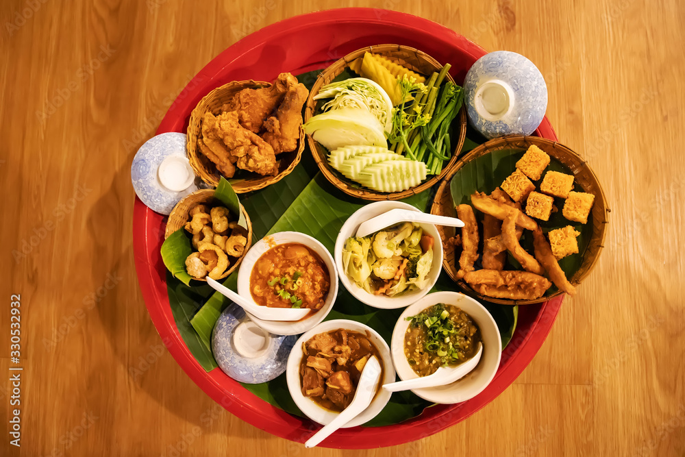 KhanToke, Khan Toke or Tok , a container for placing Lanna dishes made of wood in a cup. On the bowl, there is a young chili paste, Nam Phrik Ong, crispy pork skin, Hunglei curry and fresh vegetables.