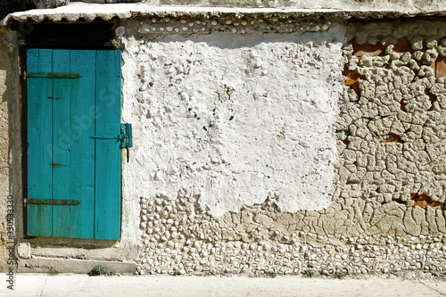 turkusowe stare drzwi w lekko zniszczonej kamienicy