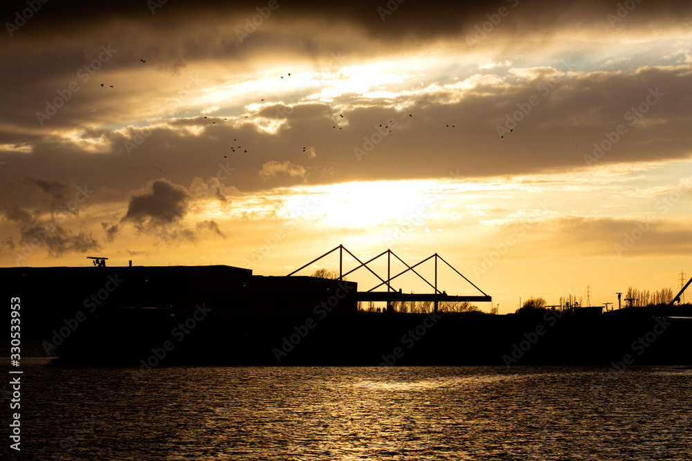 Silhouette of boats on water and one bridge
